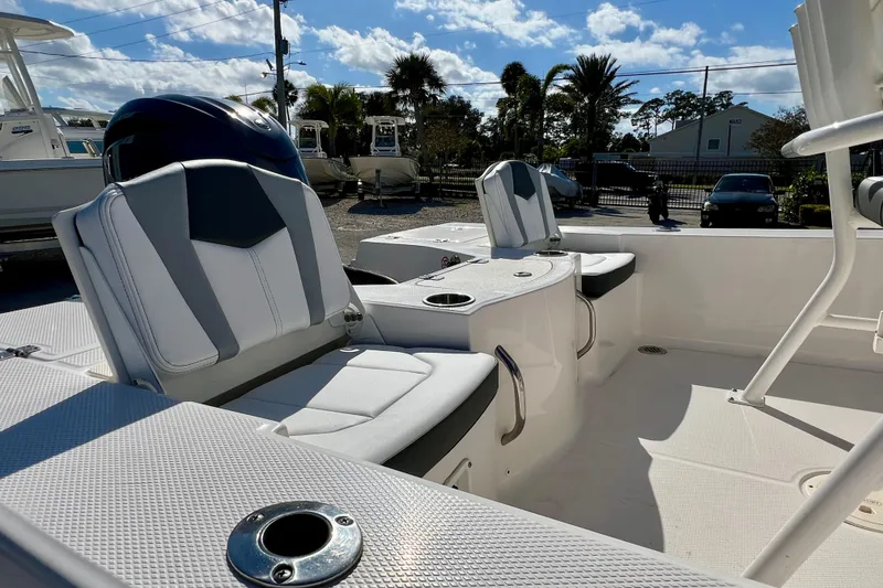 Slide: The Image of 2024 Robalo 206 Cayman boat interior with seating and cup holders under a sunny sky. - 9