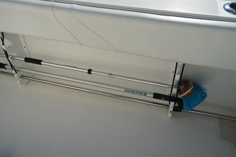 Slide: The Image of Storage area on a 2021 Edgewater 320CC boat with a mounted cleaning brush. - 15