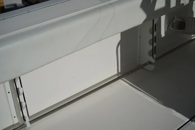 Slide: The Image of Interior view of 2021 Edgewater 320CC boat, featuring sleek white seating and storage compartments. - 16