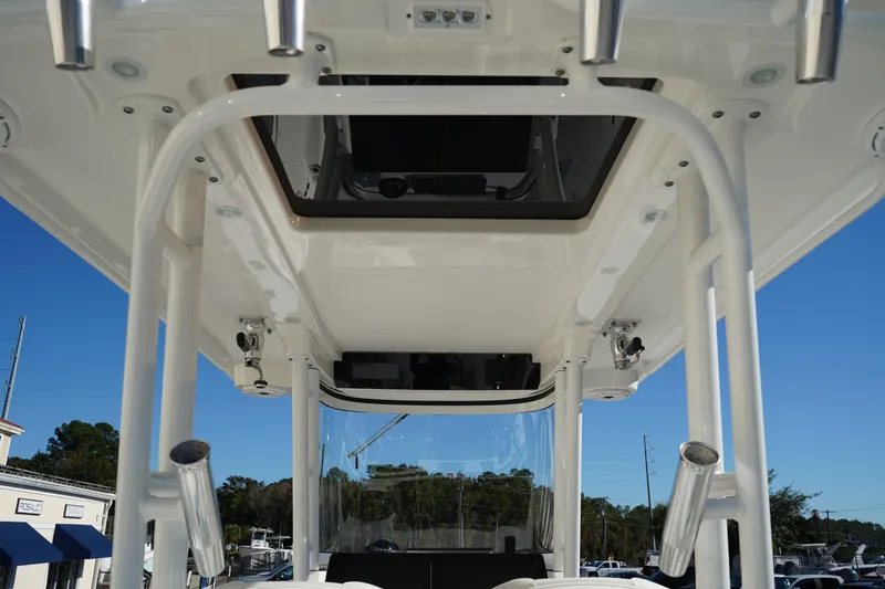 Slide: The Image of 2021 Edgewater 320CC boat's T-top and rod holders under clear blue sky. - 22