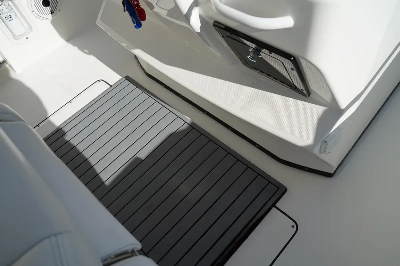Slide: The Image of Interior of 2021 Edgewater 320CC boat showing deck mat and storage compartment. - 26