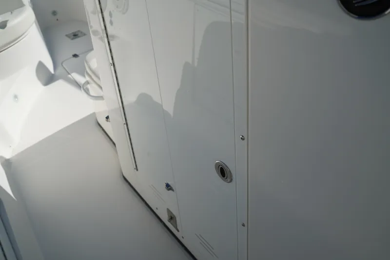 Slide: The Image of Interior view of a 2021 Edgewater 320CC boat, showcasing sleek white cabinetry. - 38