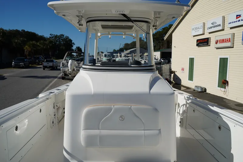 Slide: The Image of 2021 Edgewater 320CC boat docked near dealership, showcasing sleek design and spacious deck. - 42