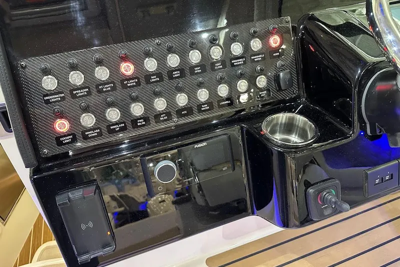 Slide: The Image of Control panel of 2026 Grady-White Express 340 boat with illuminated switches and cup holder. - 13