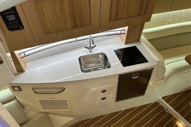 Slide: The Image of 2026 Grady-White Express 340 interior kitchen with sink, stove, and fridge. - 20