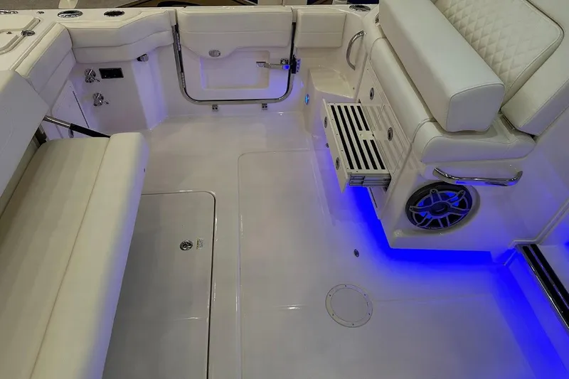 Slide: The Image of 2026 Grady-White Express 340 boat interior with blue LED lighting and cushioned seating. - 8
