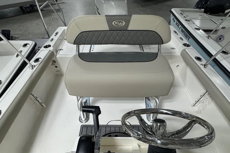 Slide: The Image of 2026 Key West 188 Bay Reef boat interior with steering wheel and cushioned seating. - 10