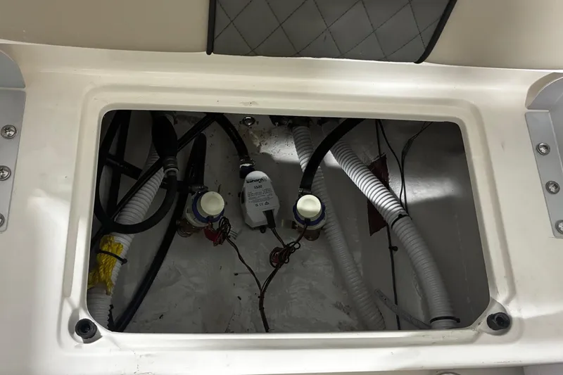 Slide: The Image of 2026 Key West 188 Bay Reef boat compartment with wiring and hoses. - 18