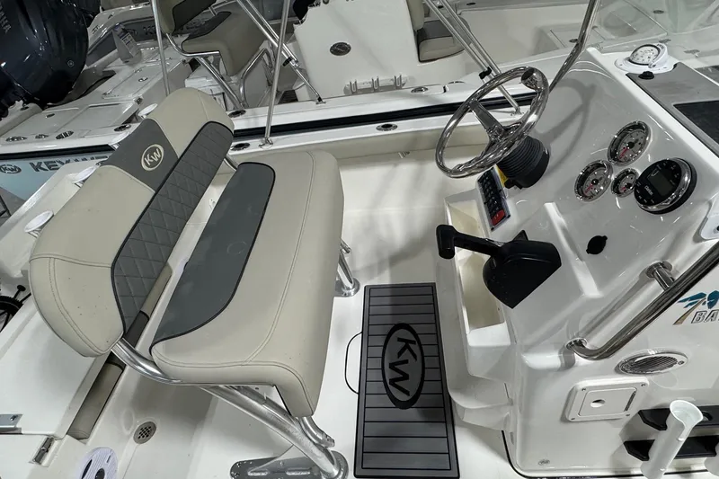 Slide: The Image of 2026 Key West 188 Bay Reef boat interior with steering console and cushioned seating. - 11