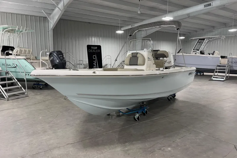 Slide: The Image of 2026 Key West 188 Bay Reef boat displayed in a showroom. - 2