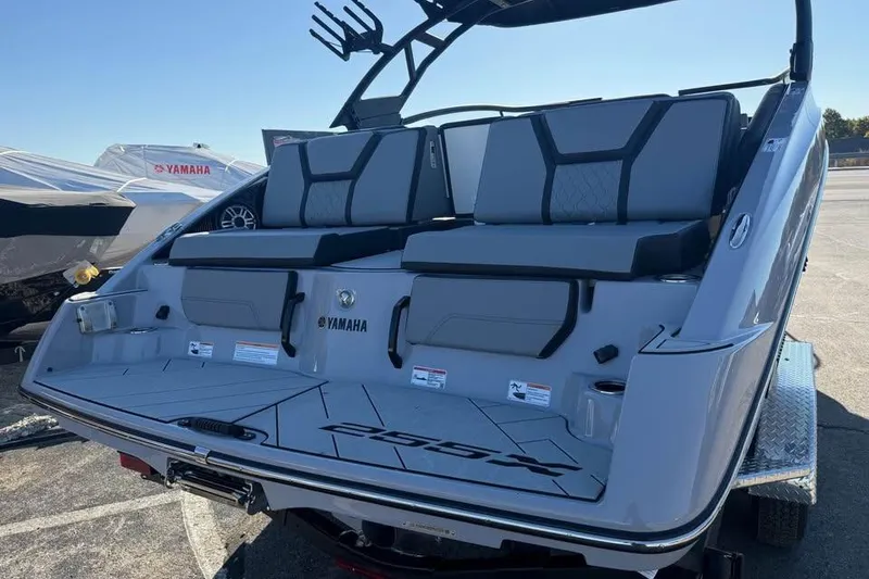 Slide: The Image of 2026 Yamaha Boats 255XD, sleek design, rear view, gray seating, outdoor display. - 5