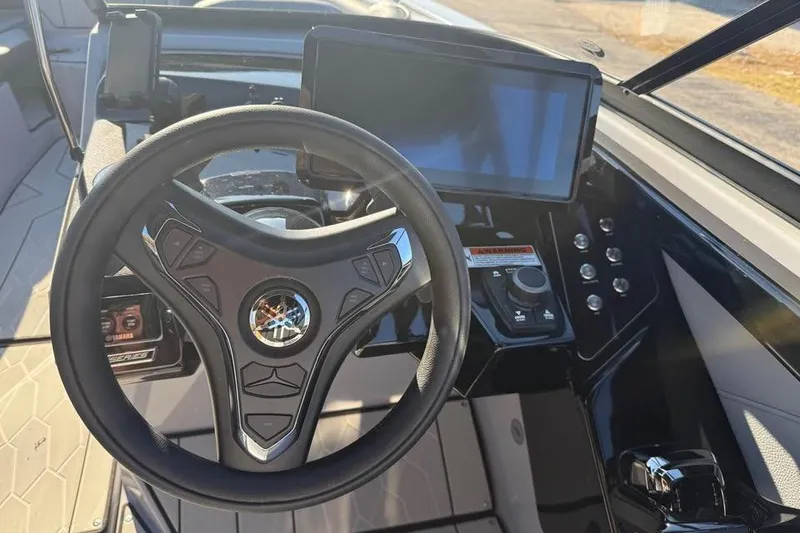 Slide: The Image of Steering wheel and dashboard of 2026 Yamaha Boats 255XD, featuring modern controls and display. - 8