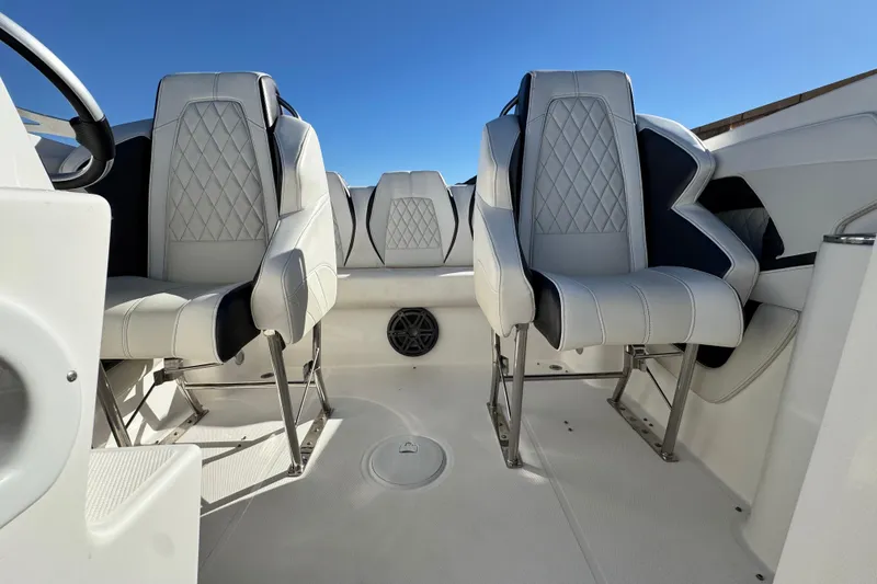 Slide: The Image of 2019 Baja 27 Outlaw boat interior with white and black seating under clear blue sky. - 20