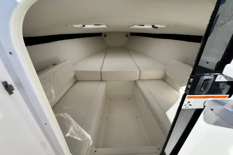 Slide: The Image of 2019 Baja 27 Outlaw cabin interior with white seating and sleek design. - 26