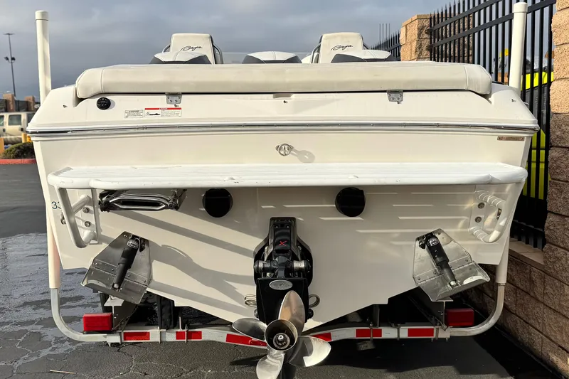 Slide: The Image of 2019 Baja 27 Outlaw boat, sleek white design, parked outdoors. - 3