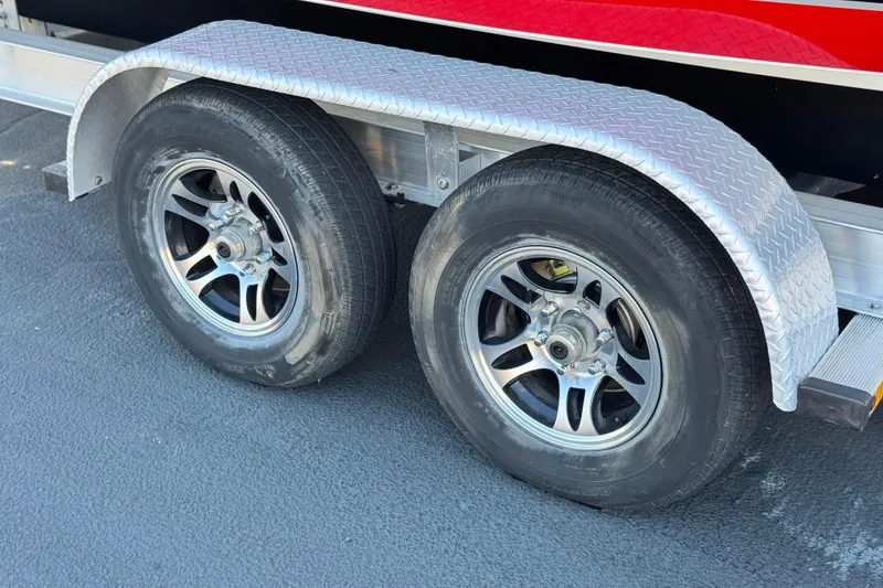 Slide: The Image of Trailer wheels of a 2019 Baja 27 Outlaw boat on a textured metal fender. - 30
