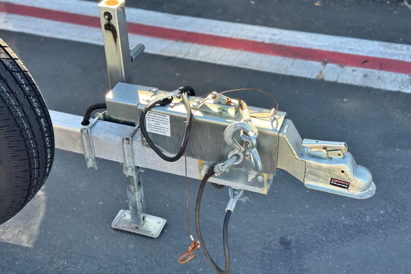 Slide: The Image of Trailer hitch of a 2019 Baja 27 Outlaw boat, featuring safety chains and coupler. - 31