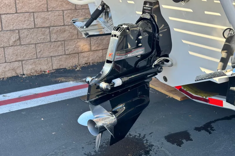 Slide: The Image of 2019 Baja 27 Outlaw boat with MerCruiser outdrive, parked on pavement. - 7