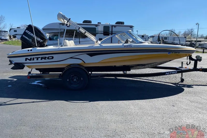 Slide: The Image of 2008 Nitro 189 Sport boat on trailer, parked outdoors, with Mercury outboard motor. - 21