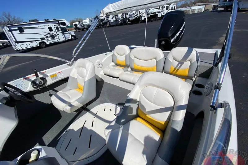 Slide: The Image of 2008 Nitro 189 Sport boat interior with white and yellow seating, parked near RVs. - 33
