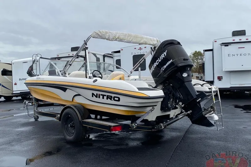 Slide: The Image of 2008 Nitro 189 Sport boat with Mercury engine, parked near RVs on wet pavement. - 6