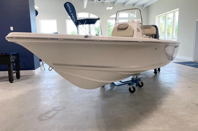 Slide: The Image of 2026 Key West 188 Bay Reef boat displayed indoors on a wheeled stand. - 4