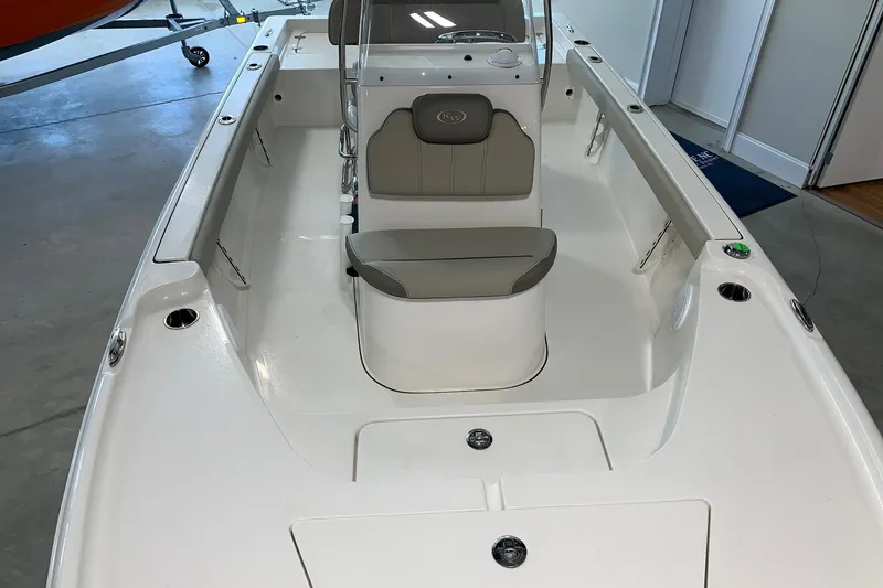 Slide: The Image of 2026 Key West 188 Bay Reef boat interior with seating and console, displayed indoors. - 20