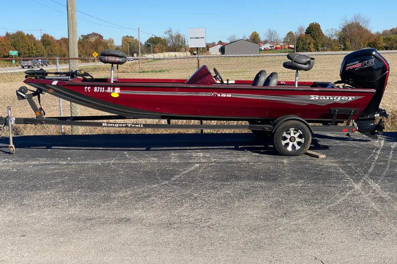 Slide: The Image of 2017 Ranger RT188 boat on trailer, red color, parked outdoors on sunny day. - 37