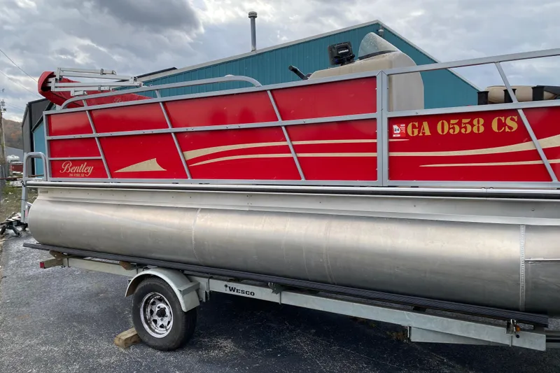 Slide: The Image of 2018 Bentley Pontoons 200 Fish boat on trailer, red exterior, parked outdoors. - 10