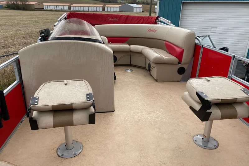 Slide: The Image of 2018 Bentley Pontoons 200 Fish interior with beige and red seating, outdoor setting. - 11