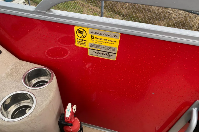 Slide: The Image of 2018 Bentley Pontoons 200 Fish interior with capacity warning label and cup holders. - 21