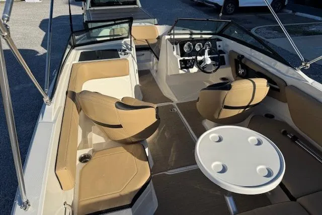 Slide: The Image of 2022 Sea Ray SPX 210 Outboard interior with tan seating and steering console. - 12