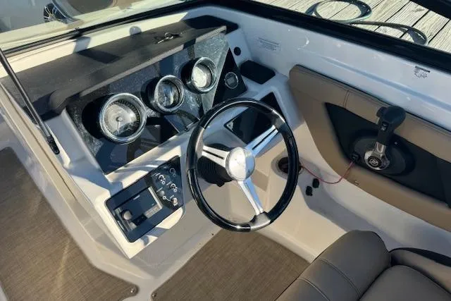 Slide: The Image of 2022 Sea Ray SPX 210 Outboard dashboard with steering wheel and gauges. - 13