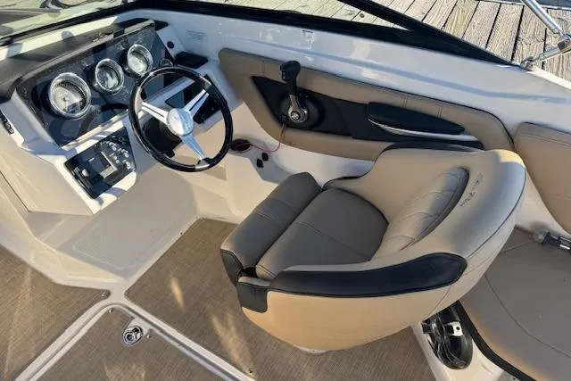 Slide: The Image of 2022 Sea Ray SPX 210 Outboard cockpit with steering wheel and beige seating. - 14