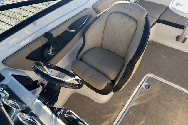 Slide: The Image of 2022 Sea Ray SPX 210 Outboard interior with steering wheel and cushioned seat. - 18
