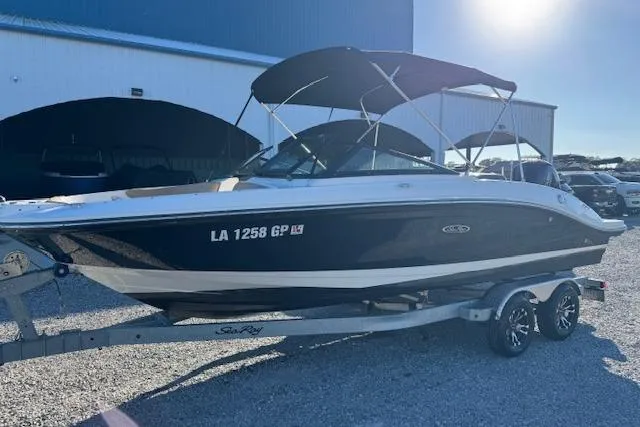 Slide: The Image of 2022 Sea Ray SPX 210 Outboard boat on trailer, parked outdoors under sunlight. - 2