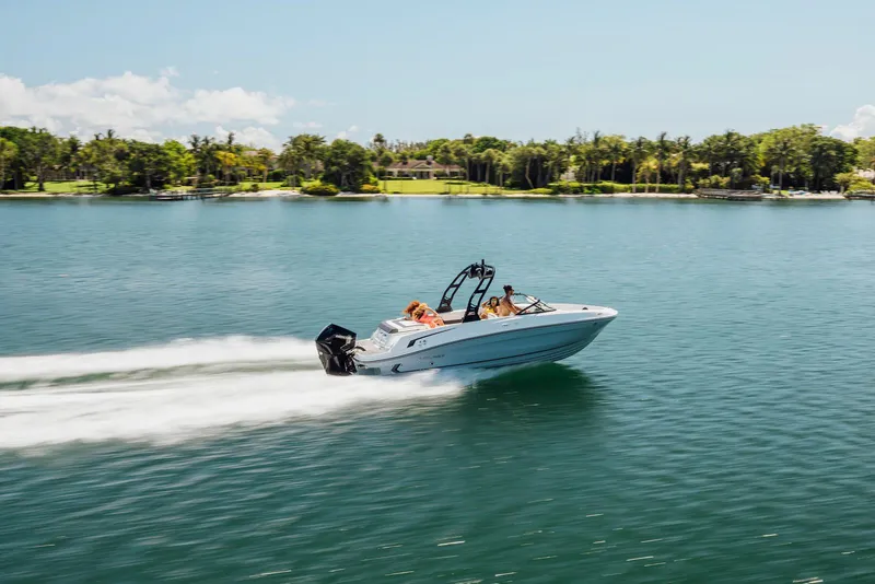 Slide: The Image of 2026 Bayliner VR6 Bowrider OB cruising on a serene lake with lush greenery. - 3