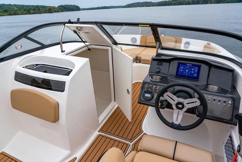 Slide: The Image of 2026 Bayliner VR6 Bowrider OB interior with modern dashboard and seating on a serene lake. - 6
