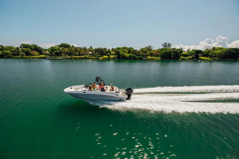 Slide: The Image of 2026 Bayliner VR6 Bowrider OB cruising on a serene lake under clear skies. - 7