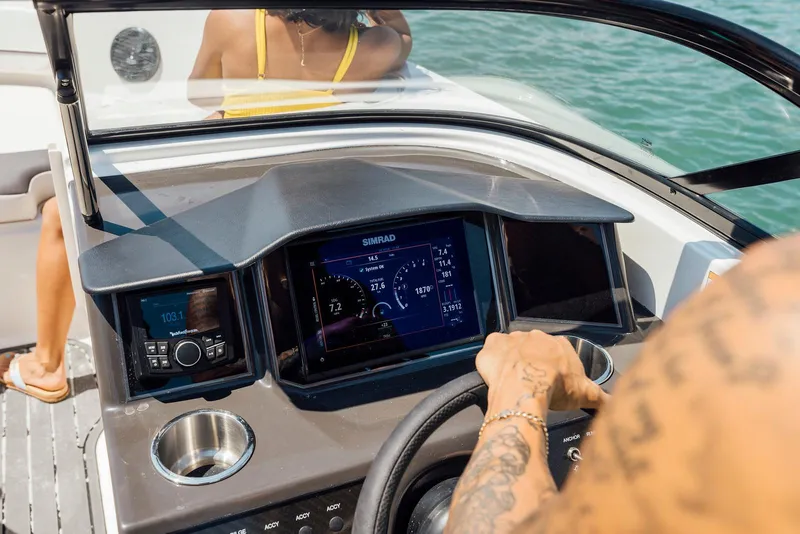 Slide: The Image of 2026 Bayliner VR6 Bowrider OB dashboard with navigation display and controls on open water. - 8