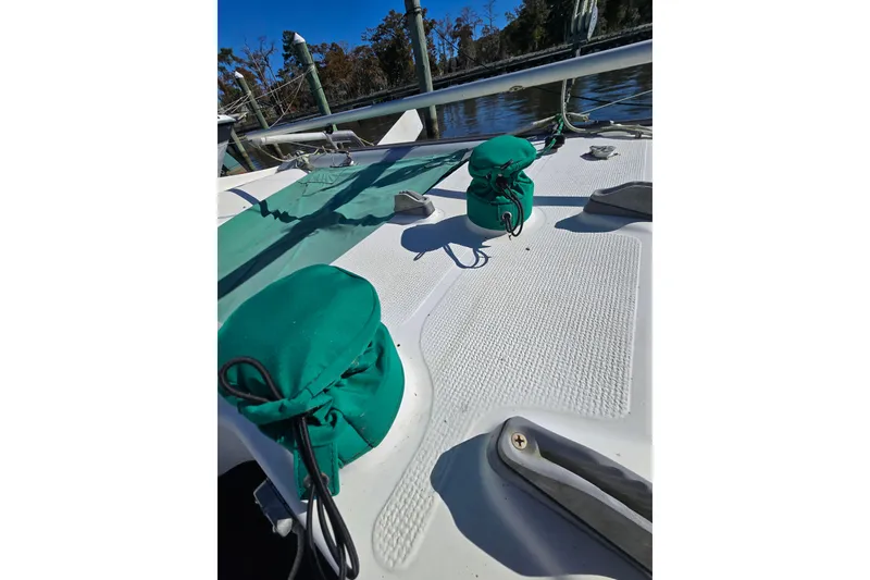 Slide: The Image of Deck of 1985 Sea Wind 24 sailboat with green covers and textured surface. - 11