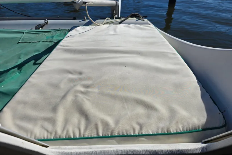 Slide: The Image of Cushioned deck area on a 1985 Sea Wind 24 sailboat, near water. - 14