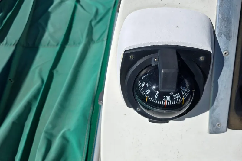 Slide: The Image of Compass on 1985 Sea Wind 24 sailboat with green cover in background. - 20