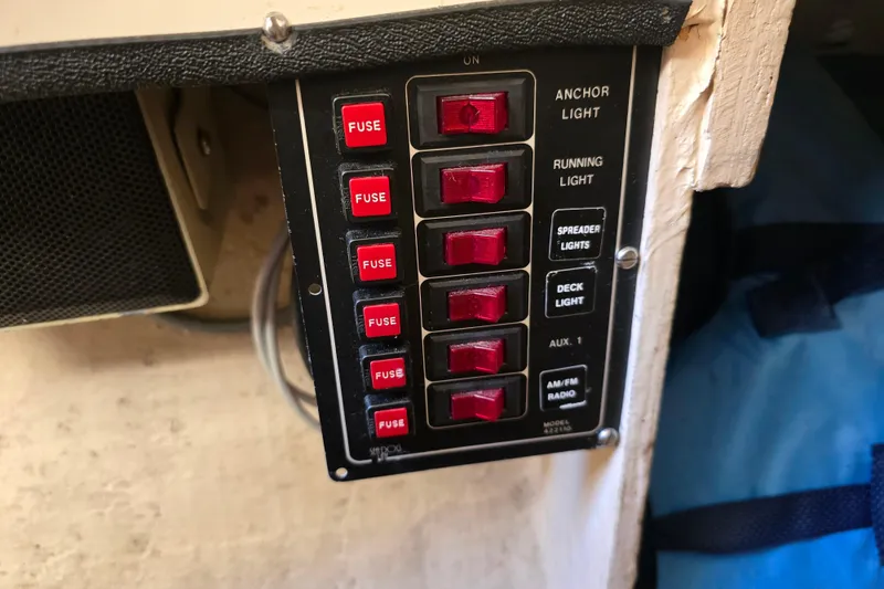 Slide: The Image of Control panel with red switches and fuses on a 1985 Sea Wind 24 boat. - 23