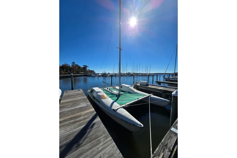 Slide: The Image of 1985 Sea Wind 24 sailboat docked under bright sun, clear blue sky. - 33