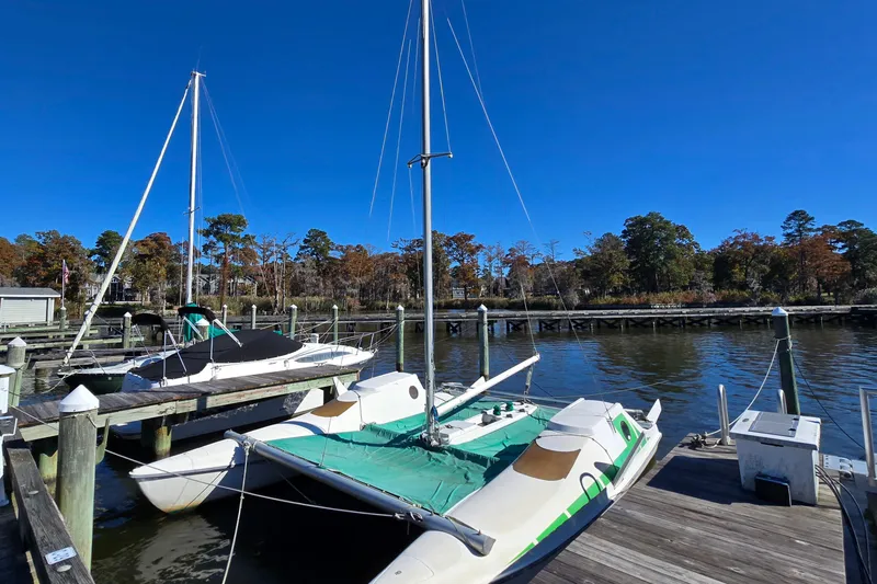 Slide: The Image of Sailboats docked at a marina, featuring a 1985 Sea Wind 24 under a clear blue sky. - 34