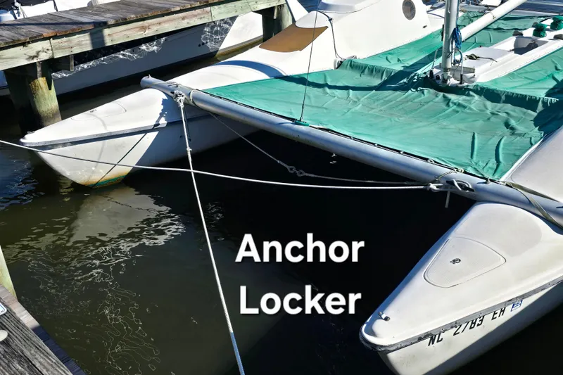 Slide: The Image of 1985 Sea Wind 24 trimaran docked, featuring anchor locker and green cover. - 6