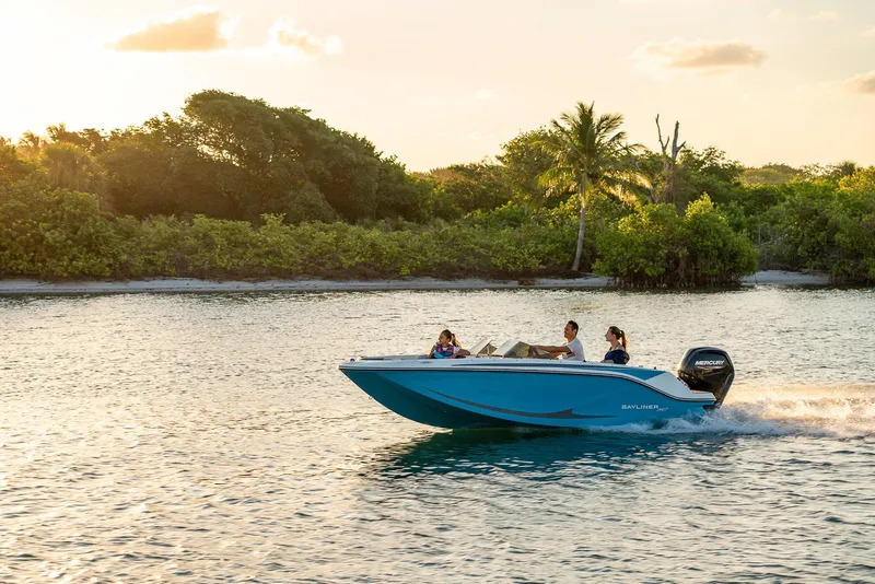 Slide: The Image of 2026 Bayliner M17 boat cruising on a serene waterway at sunset. - 2
