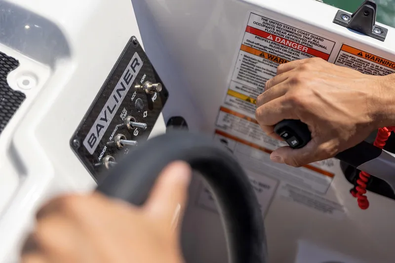 Slide: The Image of 2026 Bayliner M17 boat controls with steering wheel and safety warnings. - 3