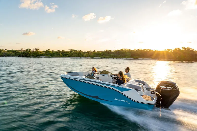 Slide: The Image of 2026 Bayliner M17 boat cruising on a serene lake at sunset. - 8